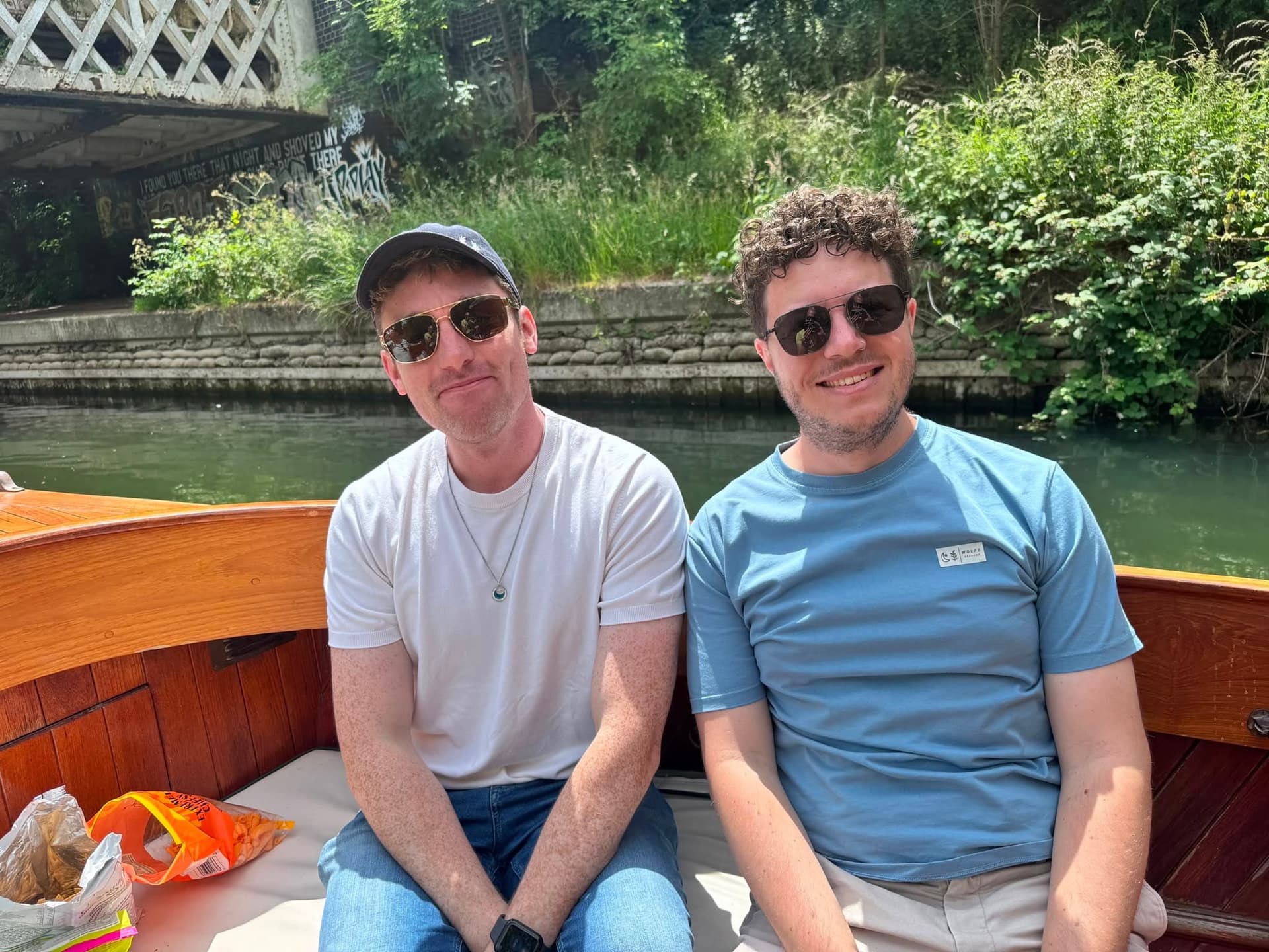 Two friends relax on a punt as it glides along the river.