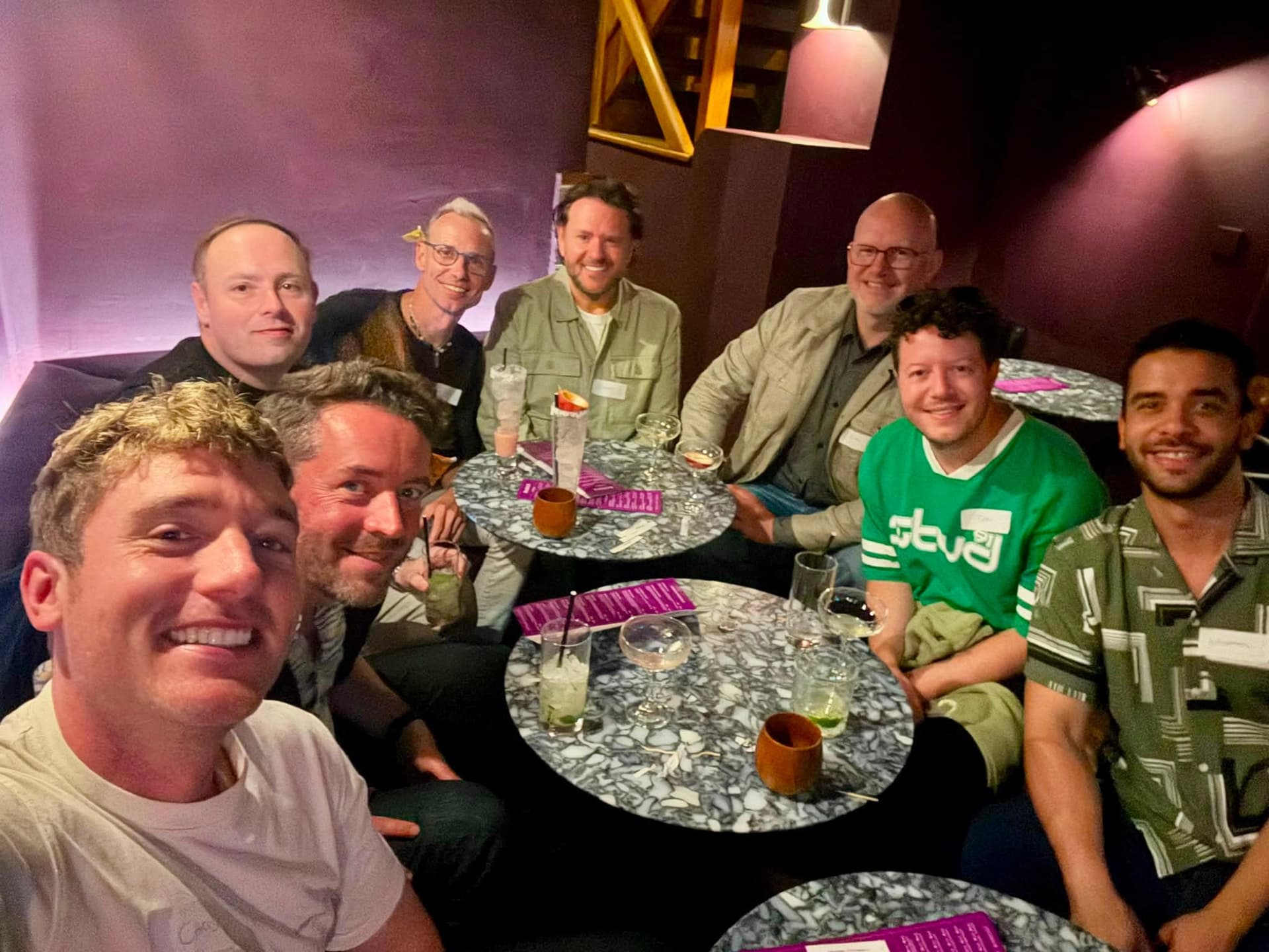 The group raises a toast around the pub table.