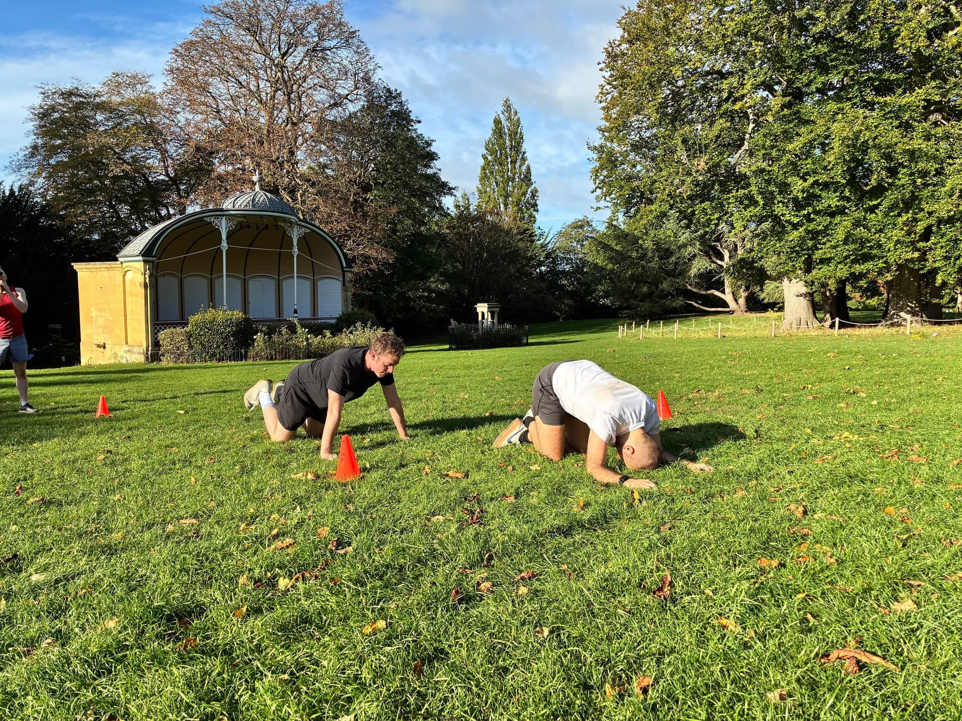 A plank challenge on the grass, others looking on.
