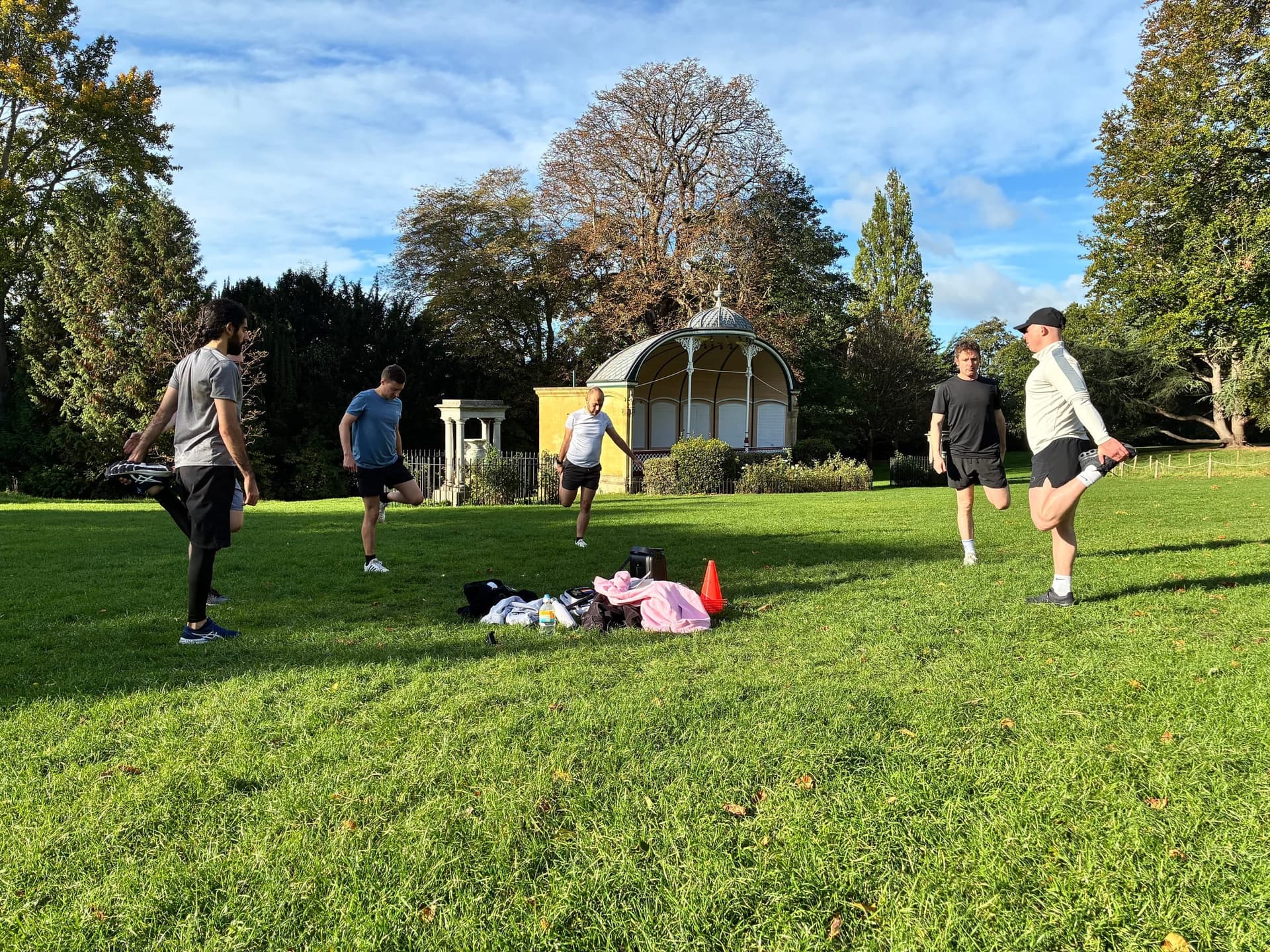 A kickabout on the grass, park in the background.