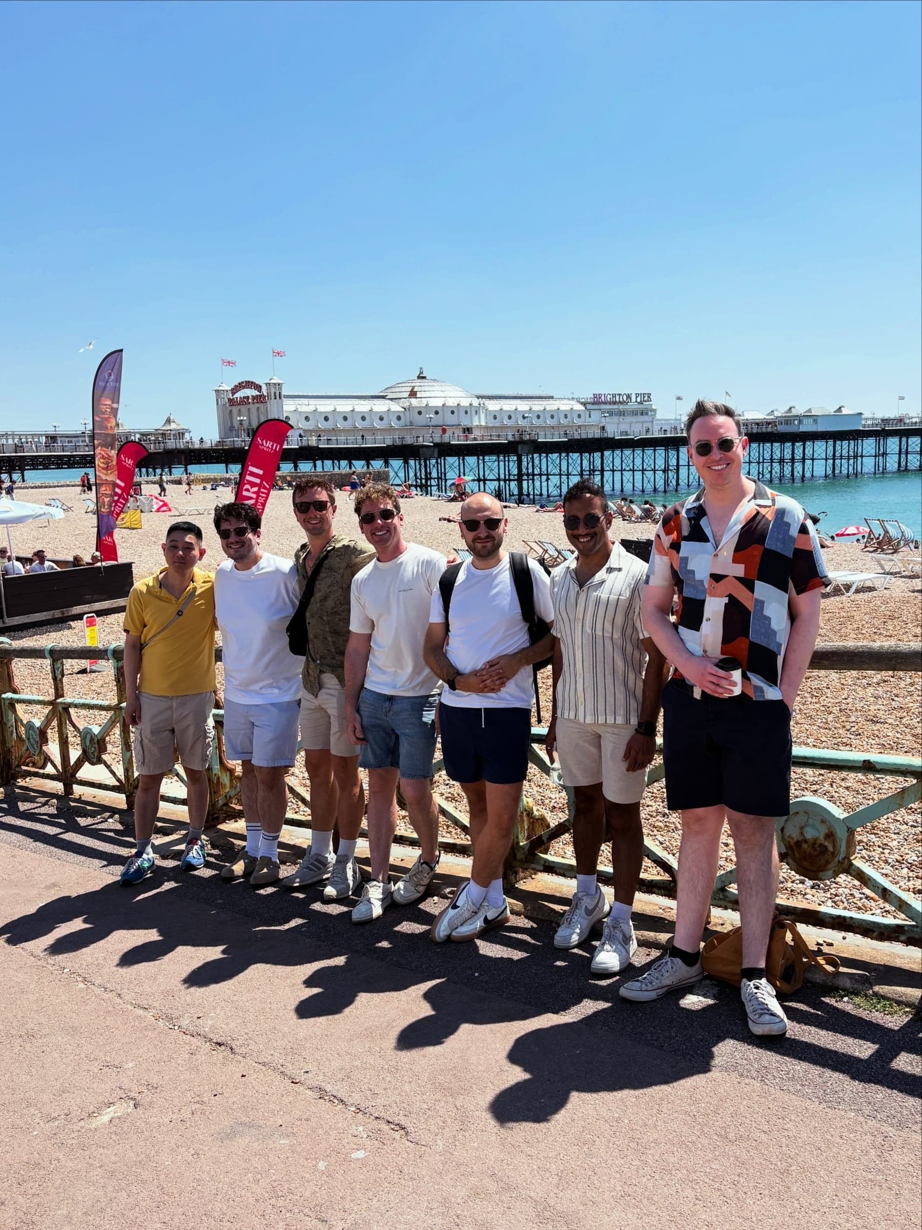 Group lined up along the seafront with the pier behind.